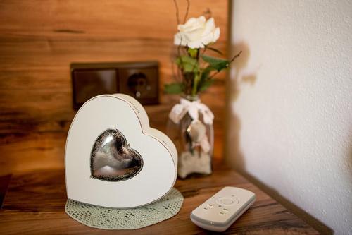 Un objeto con forma de corazón sobre una mesa junto a un control remoto. en Haus Habetseder, en Dorfgastein
