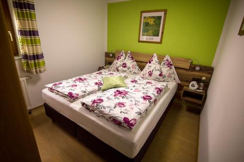 a bed in a room with a green wall at Haus Habetseder in Dorfgastein