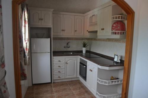 a kitchen with white cabinets and a white refrigerator at CASA ROAL in San Andrés