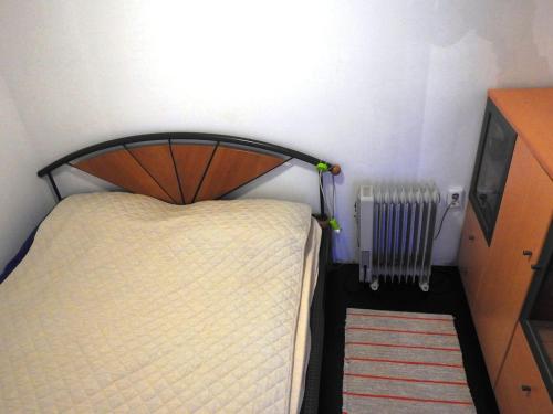 un letto con testiera in legno e un radiatore in una stanza di SEASIDE VACATION RENTAL 4TUNA a Krk