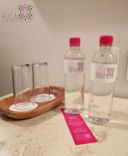 two bottles of water and two glasses on a counter at Casa Rosa Gran Hotel Boutique in Puebla