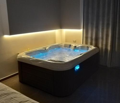 une baignoire jacuzzi dans une chambre d'hôtel avec des lumières bleues dans l'établissement B&B La Rosa Felice, à Bari