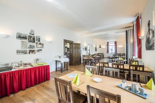 una sala da pranzo con tavoli e sedie in legno di Riemhofer Alter Schlachthof a Ratisbona