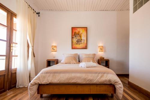 AndoharanofotsyにあるMaison entière ChezSoa, antananarivoの白い壁の大きなベッドのある寝室