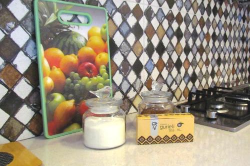 a table with two jars of milk and a box of fruit at Your apartment in Old Tbilisi-Ortachala in Tbilisi City