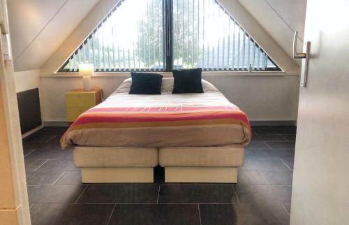 a large bed in a room with a large window at De Wolbert in Wapenveld