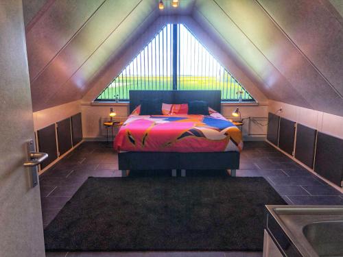 a bedroom with a bed with a large window at De Wolbert in Wapenveld
