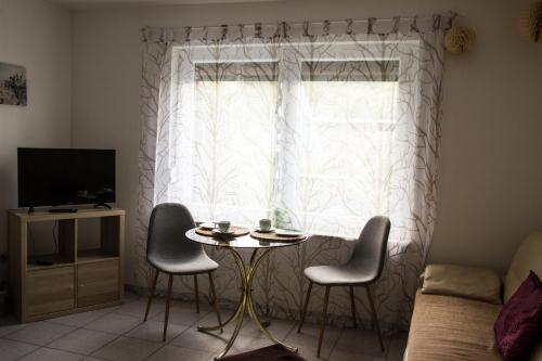 a living room with a table and chairs in front of a window at Kleines Ferienhaus zu Füßen des Rennsteigs in Ruhla