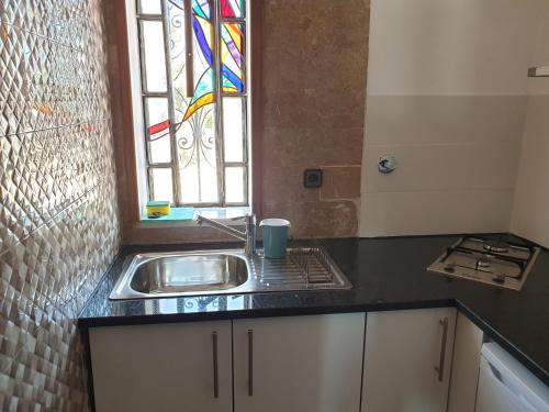 a kitchen with a sink and a stained glass window at OceanOasis Residences Suites in Olhão