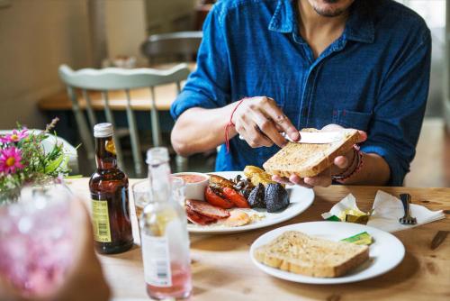 a man sitting at a table with a plate of food at Hassop Station rooms on the Monsal Trail in Bakewell