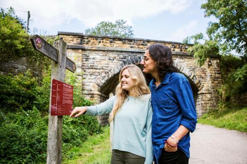 a man and a woman standing next to a sign at Hassop Station rooms on the Monsal Trail in Bakewell