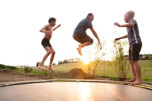 three young men jumping on top of a trampoline at Kustelberg Lodges in Medebach