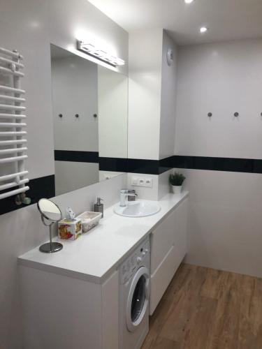 y baño con lavadora y lavamanos. en Klimatyzowany Apartament ROMA z garażem podziemnym, en Kielce