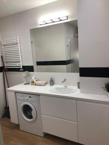 a bathroom with a sink and a washing machine at Klimatyzowany Apartament ROMA z garażem podziemnym in Kielce