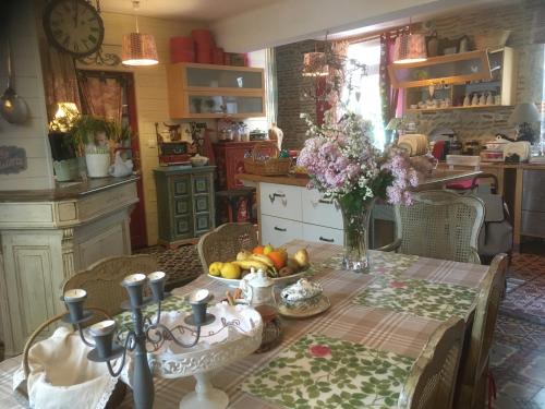 a kitchen with a table with a vase of fruit at Ô fil de L'ô in Clairac