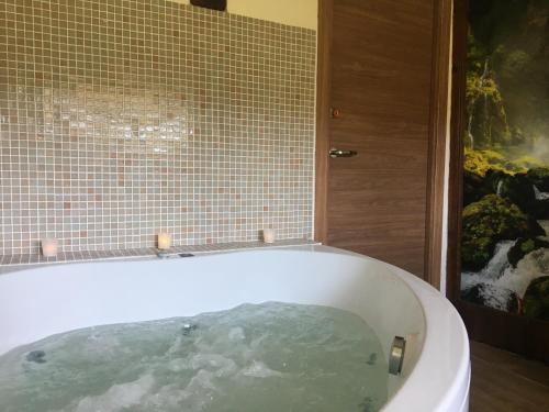 a bath tub filled with water in a bathroom at Casa Rural Las Dalias con Hidromasaje in Villafranca del Cid