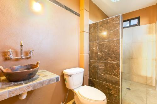 a bathroom with a sink and a toilet and a shower at Beach Front Guesthouse in Puerto Escondido