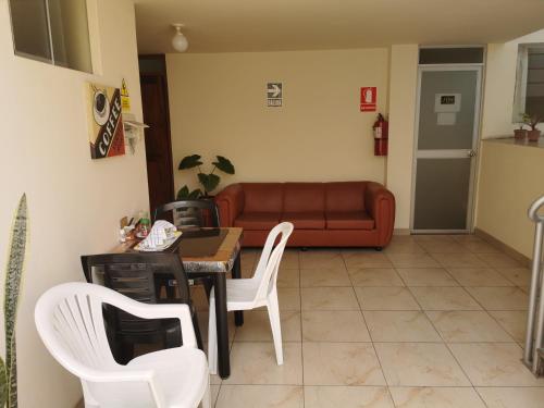 sala de estar con sofá, mesa y sillas en Residencial Mamamia, en Tacna