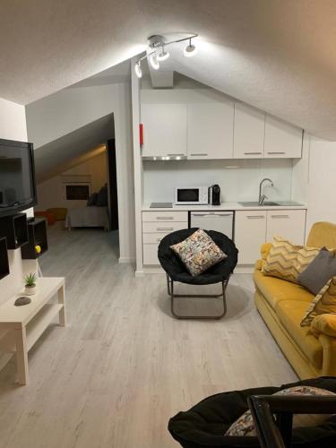 a living room with a yellow couch and a kitchen at House BLZ in Charneca