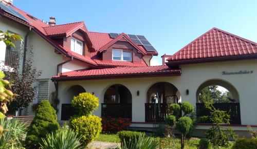 a house with a red roof at Liść Klonu in Polańczyk