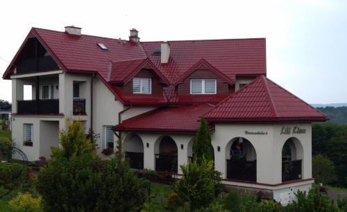 a house with a red roof at Liść Klonu in Polańczyk
