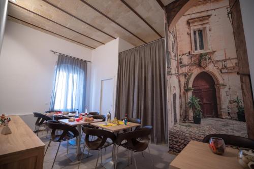 a room with tables and chairs and a fireplace at La Lupa in Matera