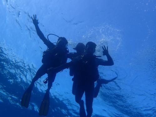 a group of three people swimming in the water at Xen Midu Hotel Addu City Maldives in Midu