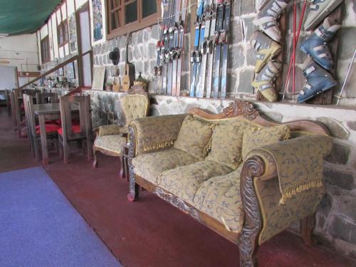 a living room with a couch and some chairs at Hostería Baños Morales in Santiago