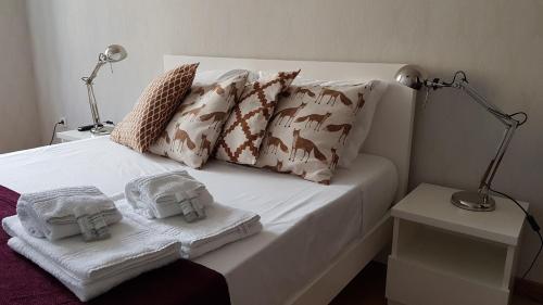 a bed with two towels and two lamps on it at Bragas Studios in Porto