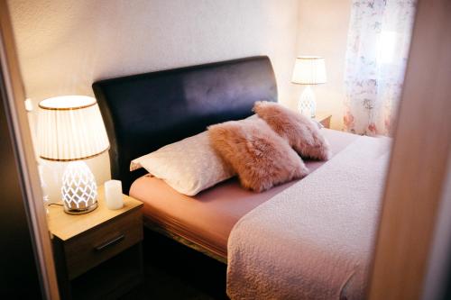 a bedroom with a bed with two furry pillows on it at Lux Apartment I Prijedor in Prijedor