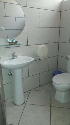 een badkamer met een witte wastafel en een toilet bij Hotel Capri in Guatemala