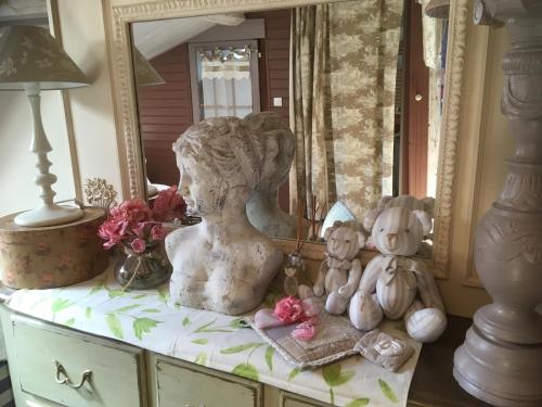 a statue of a woman sitting on a dresser next to a mirror at Ô fil de L'ô in Clairac