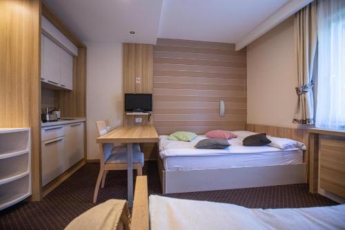 a small room with two beds and a desk at Apartments Suncani Vrhovi Kopaonik in Kopaonik