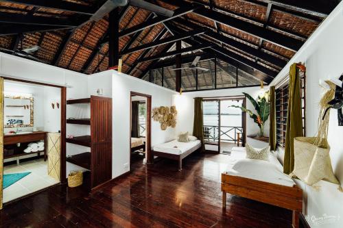 a living room with wooden floors and a wooden ceiling at Aore Island Resort in Luganville