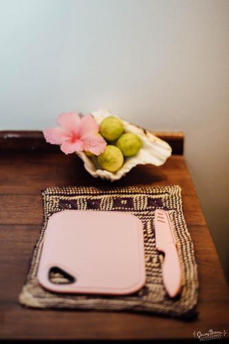 a cell phone sitting on a table with a basket of fruit at Aore Island Resort in Luganville