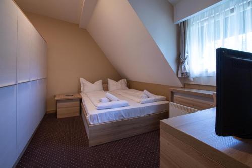 a small bedroom with a bed in a attic at Apartments Suncani Vrhovi Kopaonik in Kopaonik