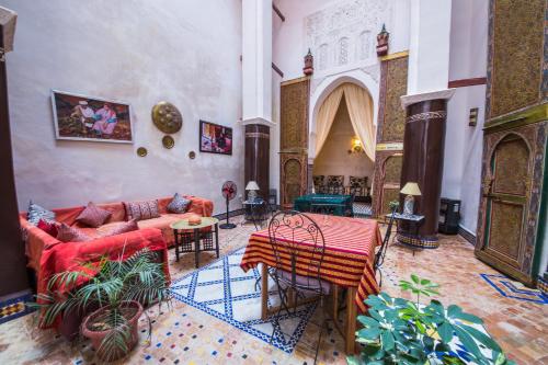 - un salon avec un canapé, une table et des chaises dans l'établissement Riad Zina Fes - Elegance in the Heart of Fes, à Fès