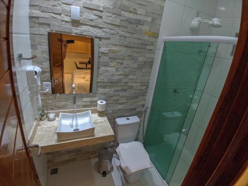 a bathroom with a sink and a glass shower at Hotel Ribeira dos Icós in Icó