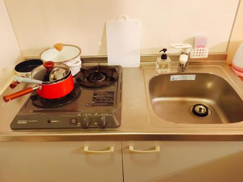 a kitchen counter with a sink and a pot on a stove at Mori de house in kobe 1 in Kobe