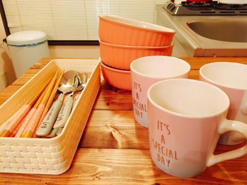 a tray of utensils and cups on a table at Mori de house in kobe 1 in Kobe