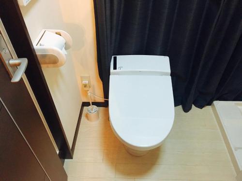 a white toilet in a bathroom with a black curtain at Mori de house in kobe 1 in Kobe