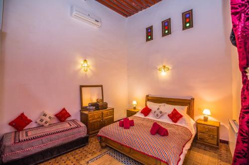 a bedroom with two beds and a mirror at Riad Zina Fes - Elegance in the Heart of Fes in Fès