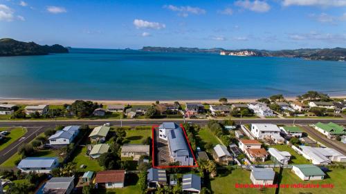 an aerial view of a town next to the water at Bayside Motel Whitianga in Whitianga