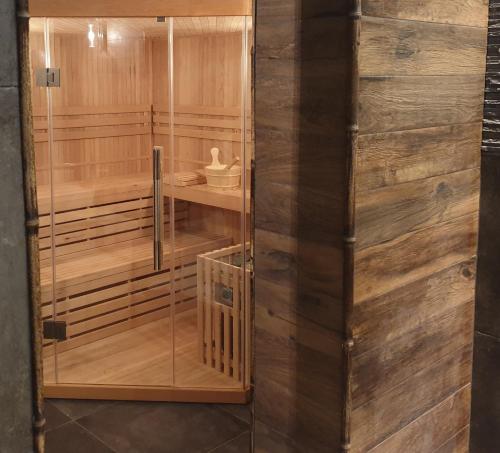 a sauna with wooden walls and a glass door at Villa Promenada in Międzyzdroje