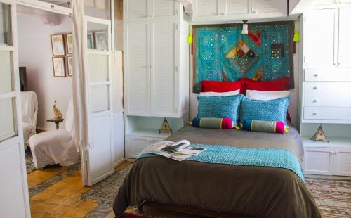 a bedroom with a large bed with colorful pillows at Riad Lunetoile in Essaouira