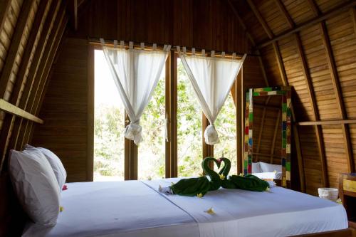 a bed in a room with a window with scissors on it at Majango Bungalows in Kuta Lombok