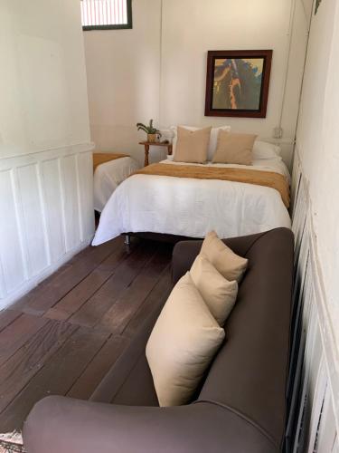 a bedroom with two beds and a couch at Ecohotel Pinohermoso Reserva Natural in Salento