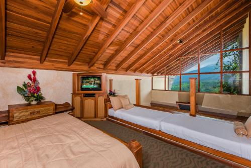 a bedroom with a large bed and a television at The Springs Resort & Spa at Arenal in Fortuna