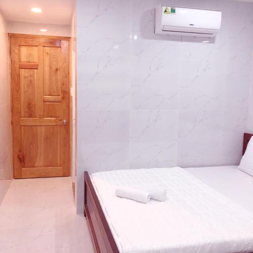 a small room with a bed and a door at Aurora Hotel in Ho Chi Minh City