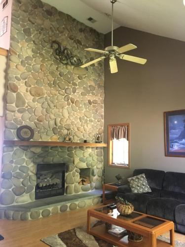 a living room with a stone fireplace at Mountain house in Palmerton